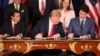 President Trump, looks over at Canada's Prime Minister Justin Trudeau's document as they and Mexico's President Enrique Pena Nieto sign a new United States-Mexico-Canada Agreement that replaces the NAFTA trade deal, at a hotel before the start of the G20 