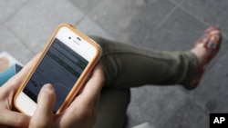 A woman uses her Apple iPhone 4 smartphone (file photo)
