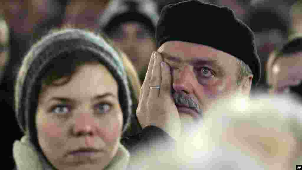 A man wipes his eyes as he attends the central event to commemorate the Fall of the Wall at the Brandenburg Gate in Berlin, Germany, Nov. 9, 2014.