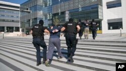 FILE - Kosovo police detain terror suspects in the capital Pristina, July 12, 2015. Around 300 Kosovars are estimated to have gone to Syria and Iraq since 2012 to fight with the Islamic State.