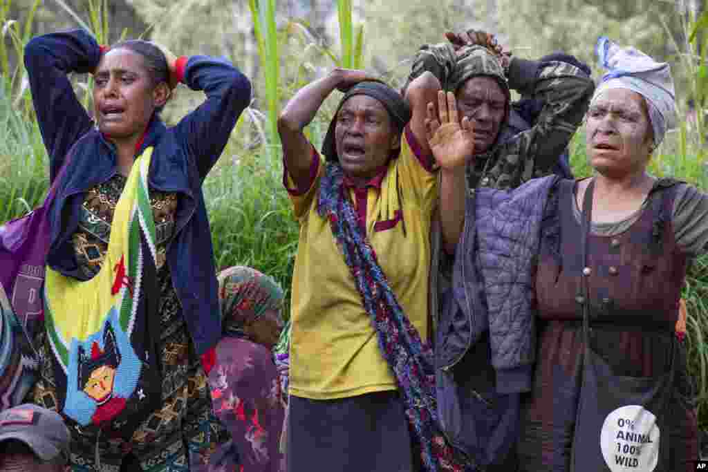 In this photo released by UNDP Papua New Guinea, villagers react as they search through a landslide in Yambali village, in the Highlands, May 27, 2024. Authorities fear a second landslide and a disease outbreak are looming at the scene of Papua New Guinea's recent mass-casualty disaster because of water streams trapped beneath tons of debris and decaying corpses seeping downhill following the May 24 landslide.