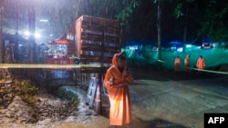 Seorang polisi Thailand berjaga di area di bawah air terjun dekat gua Tham Luang di Taman Hutan Khun Nam Nang Non di Distrik Mae Sai, Provinsi Chiang Rai, 7 Juli 2018. Operasi penyelamatan 12 remaja dari sebuah tim sepak bola dan pelatih mereka yang terjebak di gua bawah tanah masih berlanjut.
