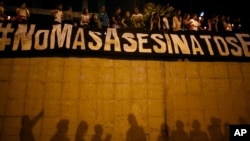 FILE - A banner reads in Spanish "No more murders" during a vigil in Caracas, Venezuela, June 8, 2017.
