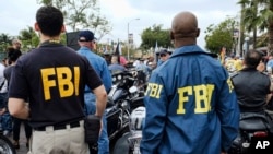 FILE - FBI agents look on as the gay pride parade kicks off in West Hollywood, Calif., June 12, 2016. 