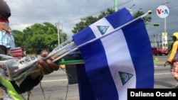 Un comerciante sostiene algunas banderas que vende por las fiestas patrias de ese país. Foto Daliana Ocaña.