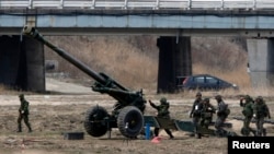 FILE - South Korean soldiers of an artillery unit take part in an artillery drill with 155mm Towed Howitzers as part of the annual joint military exercise "Foal Eagle" by the U.S. and South Korea, near the demilitarized zone (DMZ) which separates the two Koreas, Apr. 9, 2013.