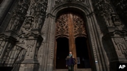 A woman wearing a face mask amid the spread of the new COVID-19 leaves the Cathedral in Mexico City, July 20, 2020. 