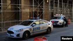 Oficiales del Departamento de Policía de la Ciudad de Nueva York (NYPD, por sus siglas en inglés) en vehículos afuera de la Oficina del Fiscal de Distrito en la ciudad de Nueva York, EEUU, el 29 de marzo de 2023.