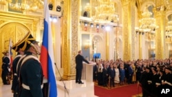 Президент Владимир Путин приносит присягу на Конституции России на церемонии инаугурации 7 мая 2018. 
