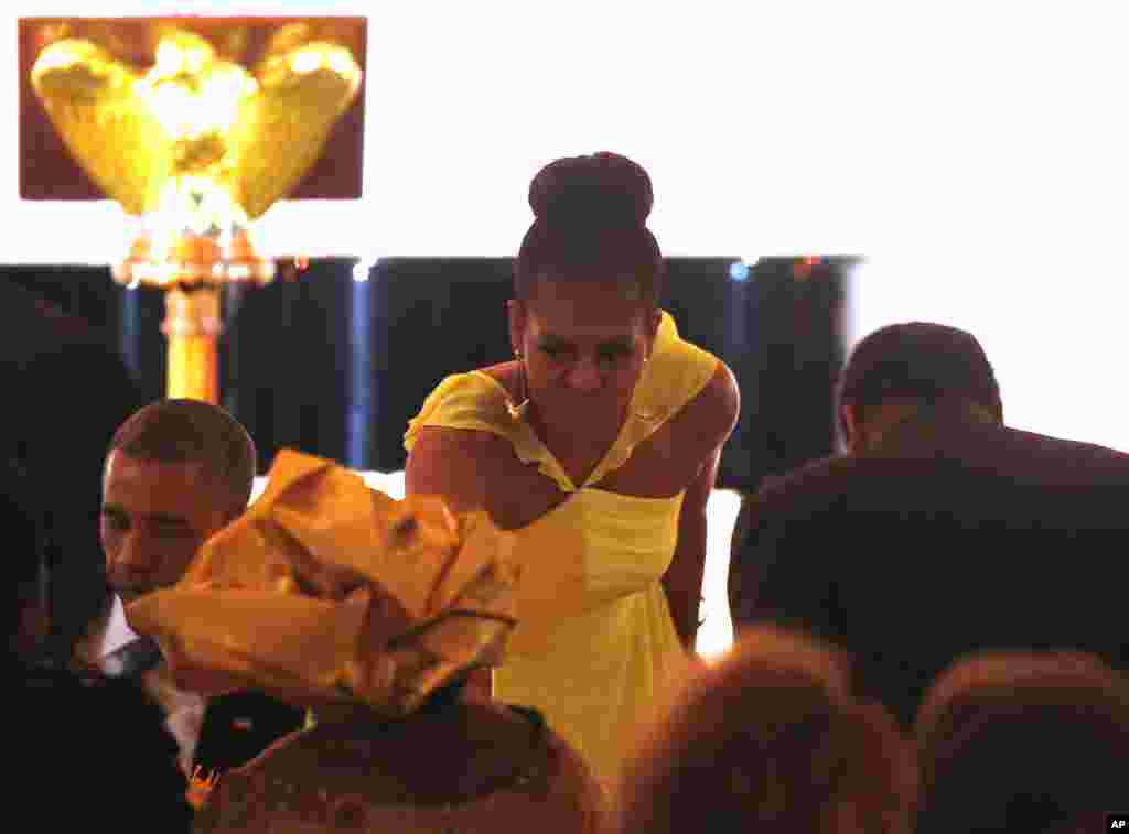 First lady Michelle Obama takes her seat following President Barack Obama's toast at a dinner for the U.S. - Africa Leaders Summit, on the South Lawn of the White House, Aug. 5, 2014.