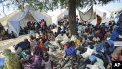 Residents gather outside United Nations Mission in Sudan sector headquarters, where as many as 40,000 people have fled fighting in the region, in Kadugli town, capital city of South Kurdufan State, Sudan, June 2011 file photo