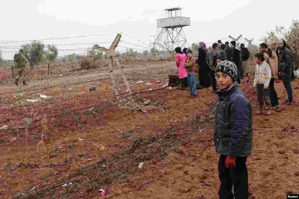Syrian refugees wait to enter Turkey on the Syrian-Turkish border in Shamm Alqrain village, Jan. 13, 2014.
