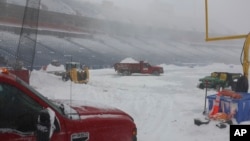 Trabajadores remueven la nieve en el Estadio Highmark en Orchard Park, Nueva York, el 14 de enero de 2024.