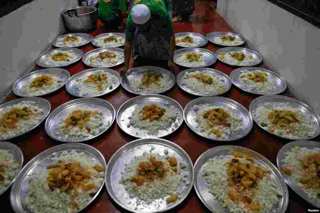 Seorang imigran ilegal Muslim Rohingya mempersiapkan hidangan berbuka puasa di Pusat Penahanan Imigrasi di provinsi Kanchanaburi, Thailand (10/7). 