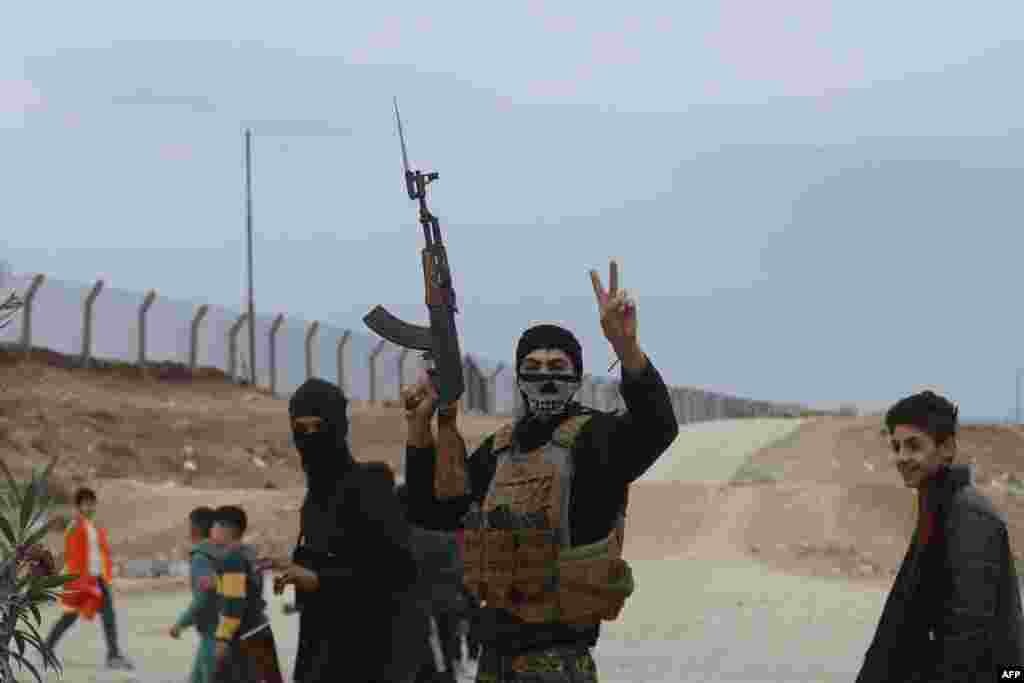 A Syrian Kurdish fighter flashes the V-sign for victory as local gunmen control the area around Qamishli's airport in northeastern Syria on Dec. 8, 2024