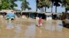 Seorang remaja Afghanistan berjalan di sepanjang jalan yang banjir di Sheikh Jalal, provinsi Baghlan, Afghanistan Minggu, 12 Mei 2024.
