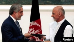Abdullah Abdullah (izquierda) y Ashraf Ghani intercambian los protocolos firmados tras el acuerdo de gobierno de unidad nacional.