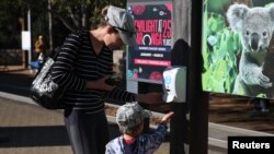 Visitors stop at a hand sanitiser station while making their way into Taronga Zoo Sydney as it re-opens to the public amidst the easing of the coronavirus disease (COVID-19) restrictions following an extended closure in Sydney, Australia, June 1, 2020. REUTERS/Loren Elliott