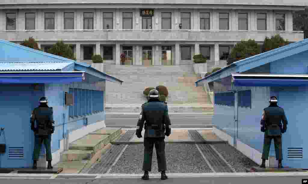 Tiga tentara Korea Selatan tampak siaga menjaga perbatasan dengan Korea Utara di Panmunjom.