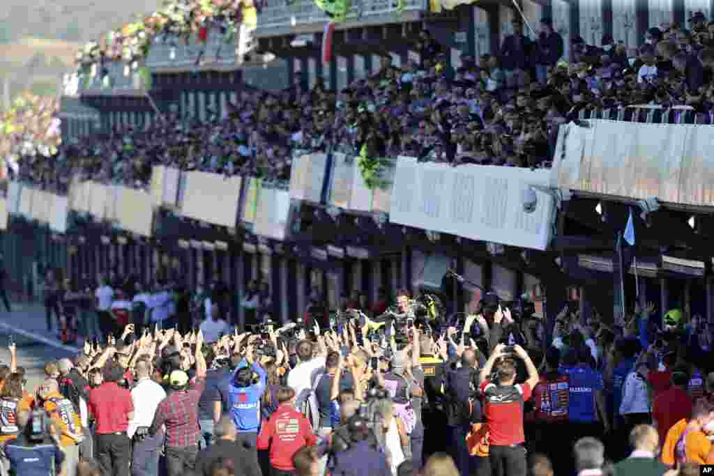MotoGP rider Valentino Rossi of Italy, center, waves at the end of the Valencia Motorcycle Grand Prix, the last race of the season, at the Ricardo Tormo circuit in Cheste, near Valencia, Spain.
