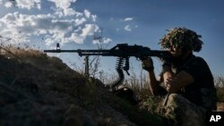 Український військовий 53-ї бригади веде вогонь з траншеї на передовій поблизу Донецька, Україна, 19 серпня 2023 року. (AP Photo/Libkos)