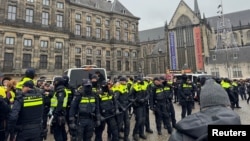 Pro-Palestinian protesters face Dutch police while taking part in a banned demonstration in Amsterdam, Nov. 10, 2024. 
