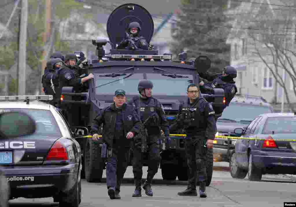 Completamente armados los efectivos del SWAT realizan una cacería en busca del sospechoso de los actos terroristas en Boston. El hombre podría cargar explosivos.
