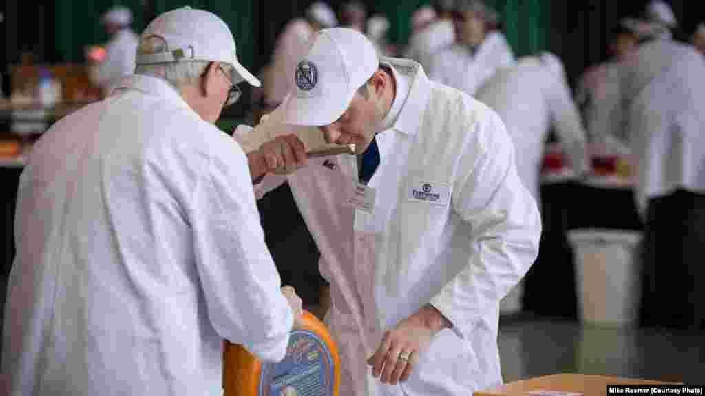 Judges smell a sample of one of the 2,555 cheeses entered in the U.S. Championship Cheese Contest, in Green Bay, Wis., March 5, 2019. Smell is just one criterion in the technical competition of the contest that began in 1981.