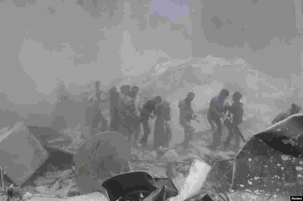 Men help evacuate civilians at a site hit by what activists said was shelling by forces loyal to Syria's President Bashar al-Assad in Aleppo's Bustan al-Qasr district.