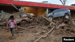 Seorang pria berjalan kawasan yang dilanda banjir dan longsor akibat hujan deras di Mocoa, Kolombia, 2 April 2017.
