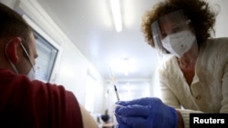 Seorang dokter memberikan suntikan vaksin COVID-19 Pfizer-BioNTech di Wina, Australia, 26 April 2021. (REUTERS/Lisi Niesner)