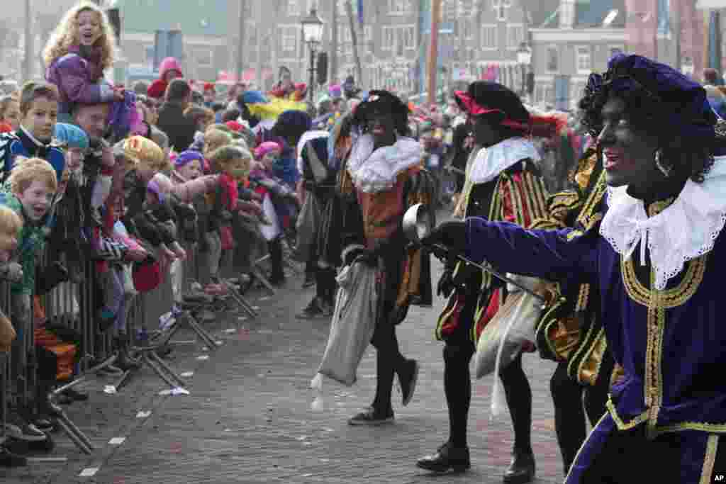 The Dutch version of Santa Claus, Sinterklaas, or Saint Nicholas, and his blackface sidekicks "Zwarte Piet" or "Black Pete" arrive by steamboat in Hoorn, north-western Netherlands, Nov. 16, 2013. The tradition is being debated, opponents say Black Petes are an offensive caricature of black people while supporters say Pete is a figure of fun whose appearance is harmless, his face soot-stained from going down chimneys to deliver present for the children.
