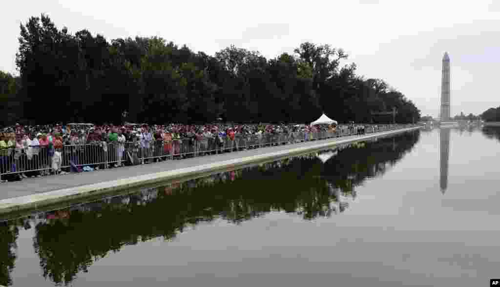 People gather around the reflecting pool near the Lincoln Memorial, Aug. 28, 2013, to listen to President Barack Obama speak during the 50th anniversary of the March on Washington.