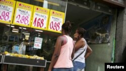 ARCHIVO - Mujeres miran precios en un mercado de alimentos en Río de Janeiro, Brasil, 21 de enero de 2016.