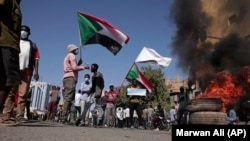 Des gens scandent des slogans et brûlent des pneus lors d'une manifestation pour dénoncer le coup d'État militaire d'octobre 2021, à Khartoum, au Soudan, le 4 janvier 2022.