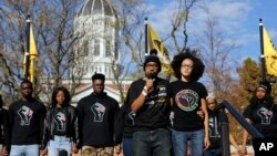Jonathan Butler, front left, addresses a crowd following the announcement that University of Missouri System President Tim Wolfe would resign Nov. 9, 2015, at the university in Columbia, Mo.