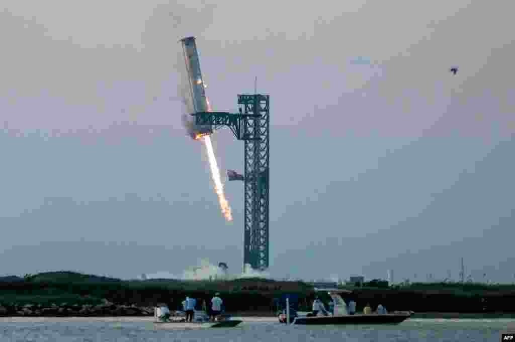 Starship's Super Heavy Booster is grappled at the launch pad in Starbase near Boca Chica, Texas, Oct. 13, 2024, during the Starship Flight 5 test. SpaceX successfully "caught" the first-stage booster of its Starship megarocket as it returned to the launch pad after a test flight, a world first in the company's quest for rapid reusability.
