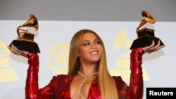FILE - Beyonce shows off the awards she won for Best Urban Contemporary Album for "Lemonade" and Best Music Video for "Formation" at the 59th Annual Grammy Awards in Los Angeles, California, Feb. 12, 2017.