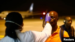 Un agent de santé vérifie la température d'un homme arrivant à l'aéroport de Bata, à Litoral, en Guinée équatoriale, le 14 janvier 2015.