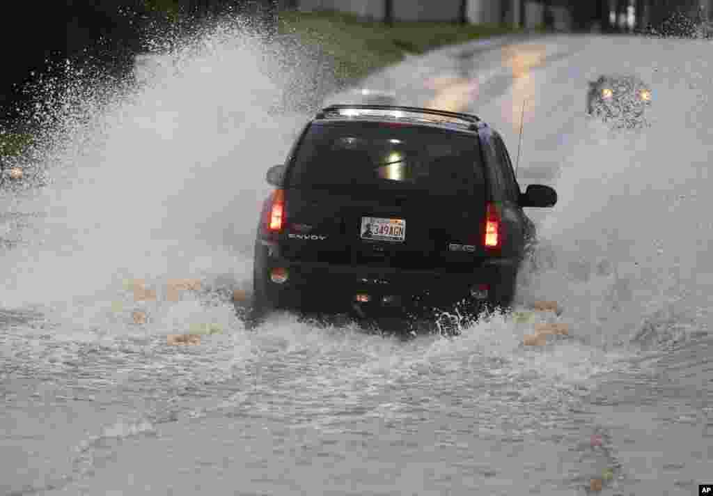 A vehicle passes through deep water following heavy rain. Forecasters declared a tornado emergency in Moore, Oklahoma, May 6, 2015.