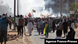 Penentang kudeta militer mengibarkan bendera nasional saat melakukan protes di Khartoum Utara, Sudan, 13 November 2021.