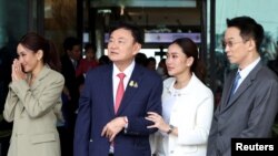 ทักษิณ ชินวัตร เดินออกจากประตูอาคารผู้โดยสารอากาศยานส่วนบุคคลของท่าอากาศยานดอนเมือง พร้อมกับลูก ๆ ทั้งสามคน ได้แก่นายพานทองแท้ ชินวัตร นางพินทองทา คุณากรวงศ์ และนางสาวแพทองธาร ชินวัตร เมื่อวันที่ 22 สิงหาคม 2566 ตามเวลาประเทศไทย (ภาพจากรอยเตอร์)