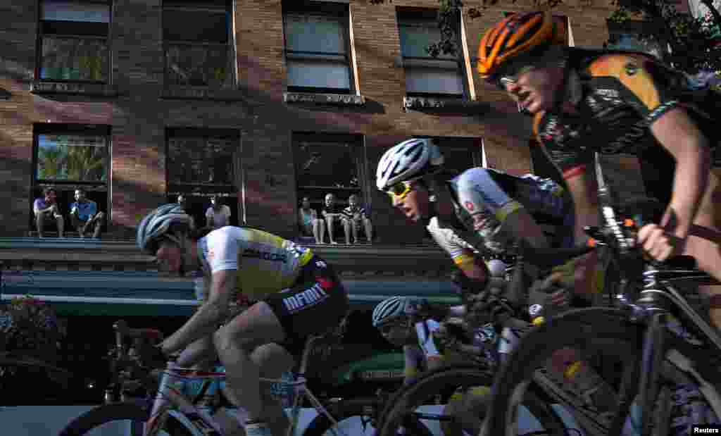 Warga menonton dari jendela saat berlangsung balap sepeda tahunan 'Gastown Grand Prix' di Vancouver, Kanada.