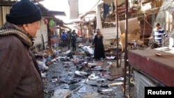 A man looks at the site of bomb attack at a marketplace in Baghdad's Doura District, Iraq, Dec. 25 2013.