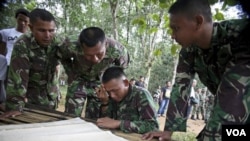 Para anggota Tim SAR mempelajari peta lokasi jatuhnya pesawat di CASA 212 Bahorok, Sumatera Utara. Evakuasi baru dilakukan Jumat pagi mengingat medan yang cukup sulit.