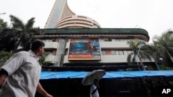 A man looks at the display screen on the facade of the Bombay stock exchange (BSE) in Mumbai, India, July 10, 2014.