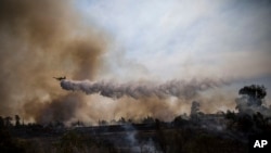 Pesawat tempur melintasi kebakaran yang disebabkan oleh balon yang diikat kain terbakar oleh warga Palestina dari Jalur Gaza di Karmia dekat perbatasan Israel dan Gaza, Kamis, 11 Oktober 2018. 
