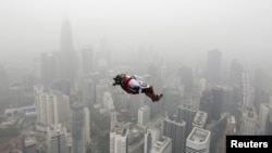 Seseorang melakukan aksi melompat dari ketinggian 300 meter dari Kuala Lumpur Tower di tengah hari berkabut asap di kota itu (2/10). (Reuters/Olivia Harris)