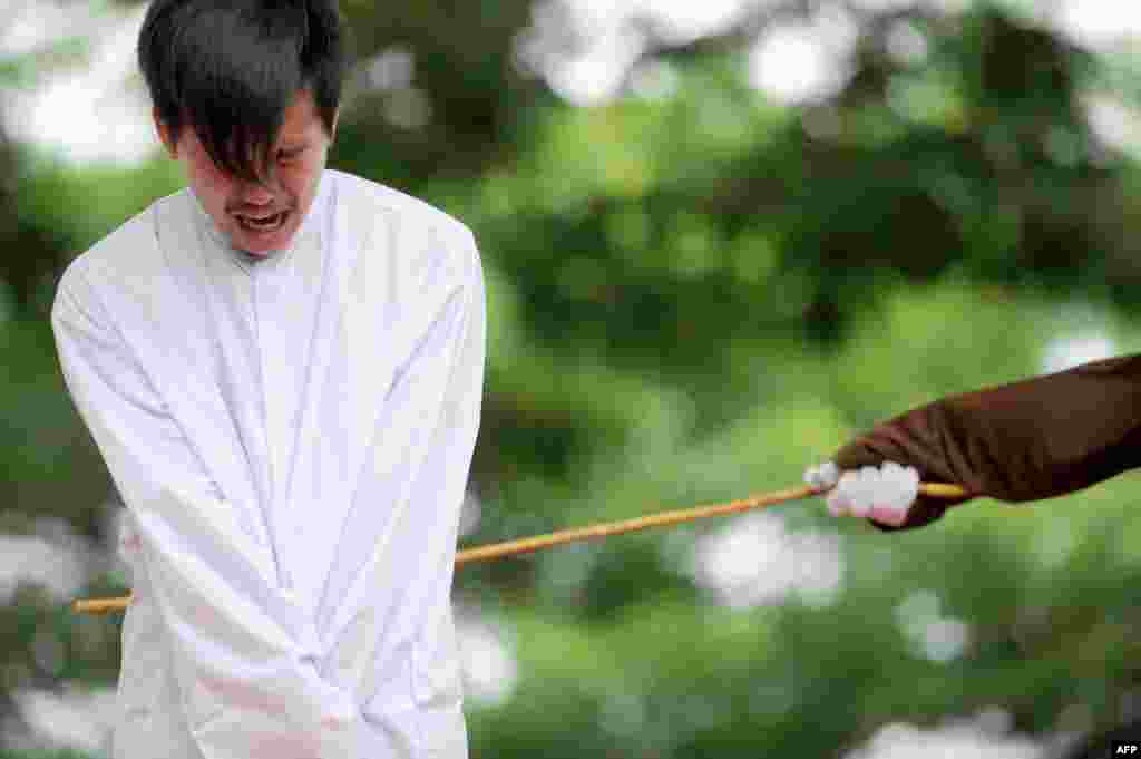 Seorang pria gay menjalani hukuman cambuk 83 kali di depan publik di Banda Aceh, provinsi Aceh, Selasa (23/5).