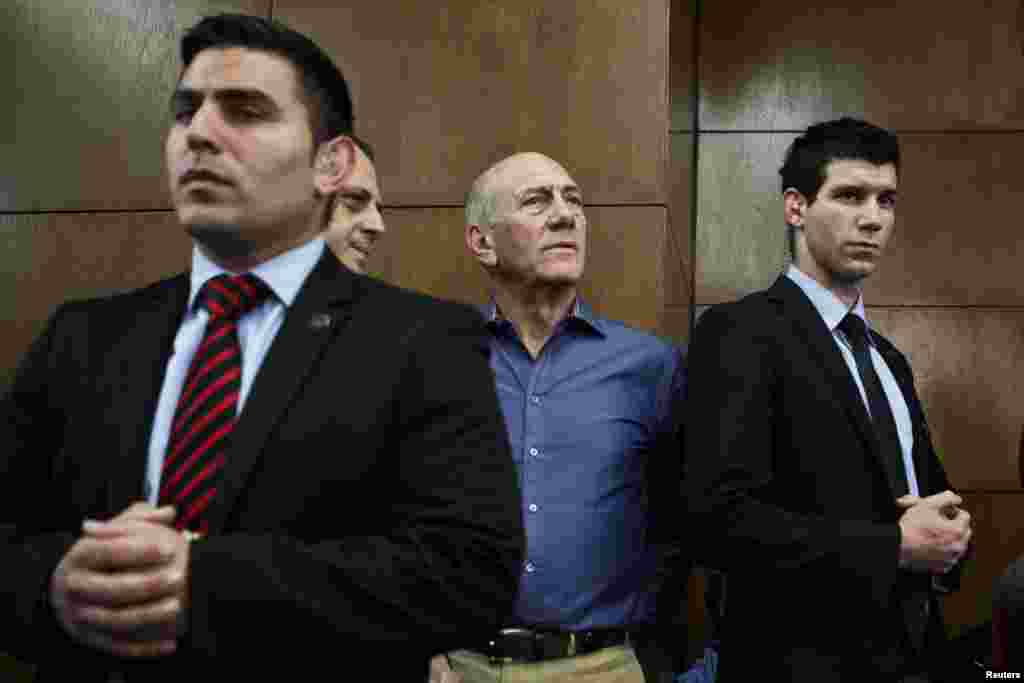 Former Israeli prime minister Ehud Olmert (2nd right) waits to hear his verdict at the Tel Aviv District Court March 31, 2014. 